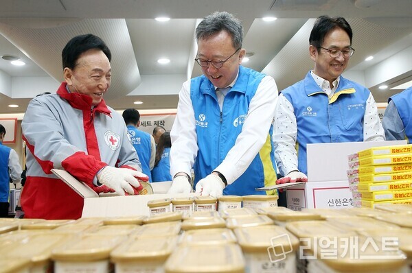 서울 중구 대한적십자사 서울사무소에서 진행된 ‘긴급비상식량세트’ 제작 봉사활동에서 정상혁 신한은행장(가운데)과 김철수 대한적십자사 회장(왼쪽), 신한은행 임원들이 식량세트를 제작하고 있다. 신한은행 제공