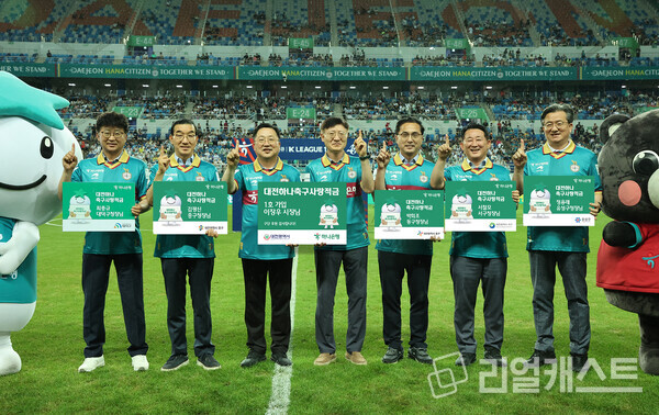 하나은행이 지난해 7월 22일에 열린 대전하나시티즌 홈경기에서 '대전하나 축구사랑 적금' 출시 기념 행사를 가졌다. (사진 왼쪽부터 최충규 대덕구청장, 김광신 중구청장, 이장우 대전광역시장, 이승열 하나은행장, 박희조 동구청장, 서철모 서구청장, 정용래 유성구청장). 하나은행 제공
