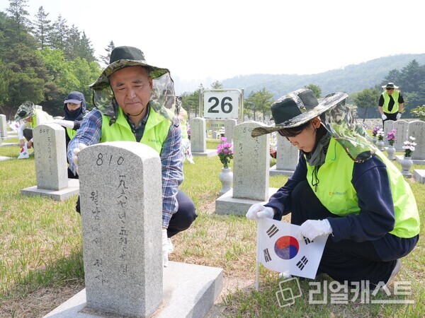 문상철 홍보실장(왼쪽)과 홍보실 직원이 현충원 묘역 정화활동을 하고 있다/ 농협중앙회