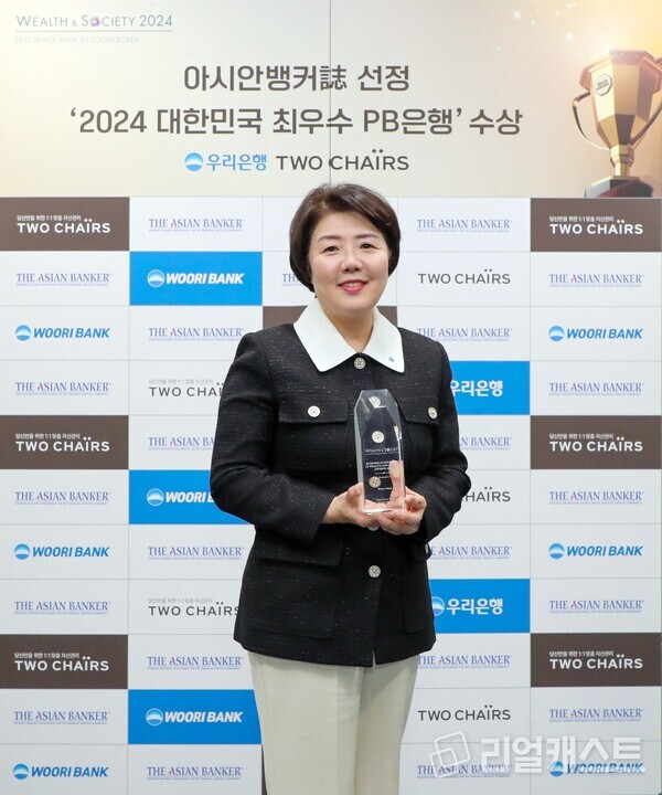 우리은행 송현주 자산관리그룹장이 아시안뱅커가 수여한 ‘글로벌 웰스 앤드 소사이어티 어워즈(The Global Wealth & Society Awards 2024)' 수상 트로피를 들고 기념촬영을 하고 있다. 출처 : 우리은행