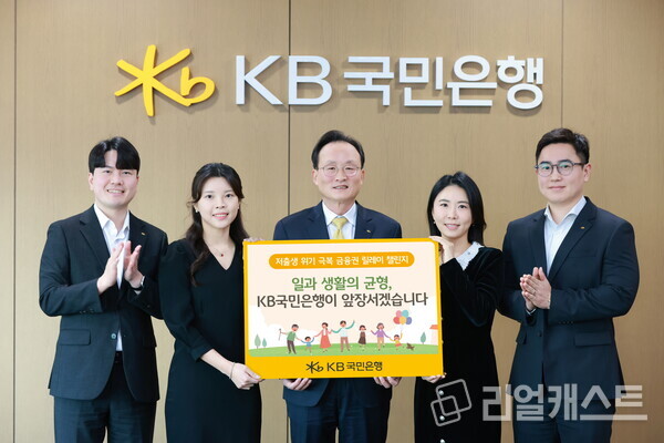 서울시 영등포구에 위치한 KB국민은행 신관에서 이환주 KB국민은행장(가운데)과 ‘KB아이사랑적금’를 기획한 KB국민은행 수신상품부 직원들이 '저출생 위기 극복 챌린지'에 참여해 기념 촬영을 하고 있다. 출처 : KB국민은행