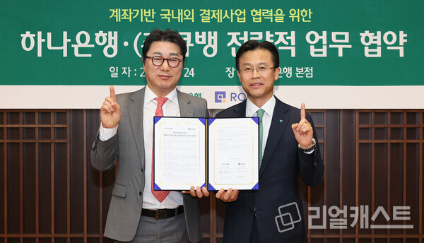 이날 협약식에 참석한 서유석 하나은행 기업그룹 부행장(사진 오른쪽)이 강신혁 큐뱅 대표(사진 왼쪽)과 협약서를 들고 기념촬영을 하고 있다. 출처 : 하나은행