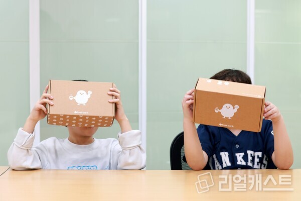 가정폭력쉼터 내 아이들이 '토스뱅크 응원키트'를 들고 빠른 일상 회복을 바라며 얼굴을 가린 채 사진을 찍고 있다. 출처 : 토스뱅크