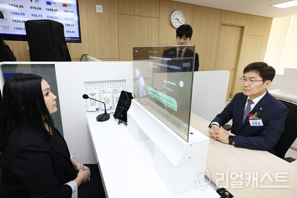 13일 경기도 안산시에 위치한 IBK기업은행 안산외국인금융센터에서 김형일 IBK기업은행 전무이사(오른쪽)가 실시간 통번역서비스 시스템을 시연하고 있는 모습. 출처 : IBK기업은행