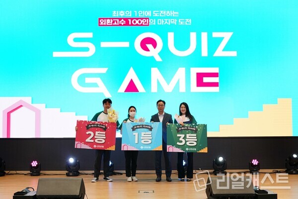 지난 13일 서울시 중구 소재 신한은행 본점에서 외환 퀴즈대회 ‘S-QUIZ Game(스퀴즈 게임)’ 최종 본선 행사를 진행하고 이봉재 신한은행 고객솔루션그룹장 및 우수한 성적을 거둔 1~3등 직원들이 기념 촬영하는 모습. 출처 : 신한은행