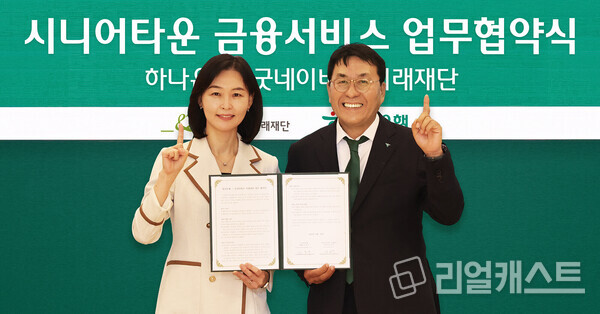 이날 협약식에 참석한 김진우 하나은행 중앙영업그룹 부행장(사진 오른쪽)이 양진옥 굿네이버스 미래재단 대표(사진 왼쪽)와 함께 업무협약서를 들고 기념 촬영을 하고 있다. 출처 : 하나은행