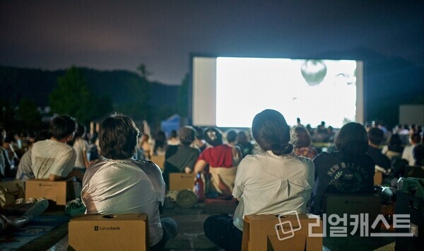 지난 8월 1일부터 3일까지 강원도 강릉시 정동초등학교에서 열린 ‘제27회 정동진독립영화제’에 방문한 참여자들이 영화를 관람하고 있다. 카카오뱅크는 이번 행사에 총 5000만 원을 기부했다. 출처 : 카카오뱅크