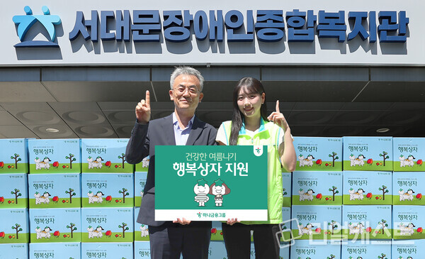 이날 행사에 참석한 하나금융 직원이 송용성 서대문장애인종합복지관장(사진 왼쪽)에게 행복상자를 전달하며 기념촬영을 하고 있다. 출처 : 하나금융